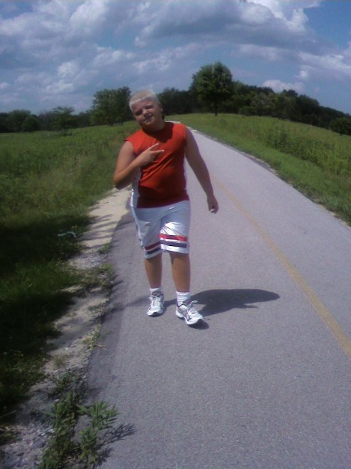 0720091440 One mile. Sweating and cranky, but still manages to flash the peace sign. Kids!